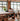 Person working at a long table in a modern office with large windows.