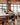 Person working at a long table in a modern office with large windows.